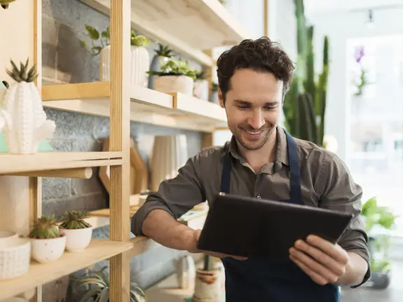 Florist using digital tablet in flower shop
