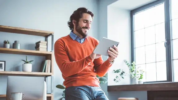 Businessman leaning on the table and working on digital tablet