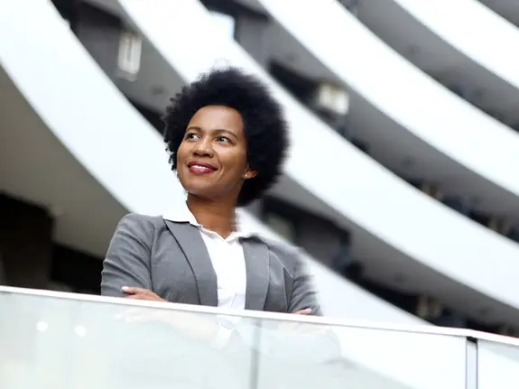 black business woman looking away with arms crossed and a dreamer look